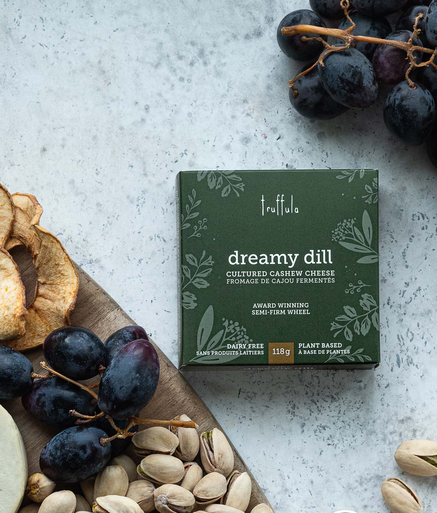 Dreamy Dill Truffula Cheese Truffula Dreamy Dill cheese box on a white background beside a charcuterie board.